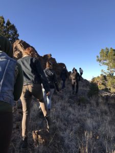 7 people wearing jackets hiking in the daytime.